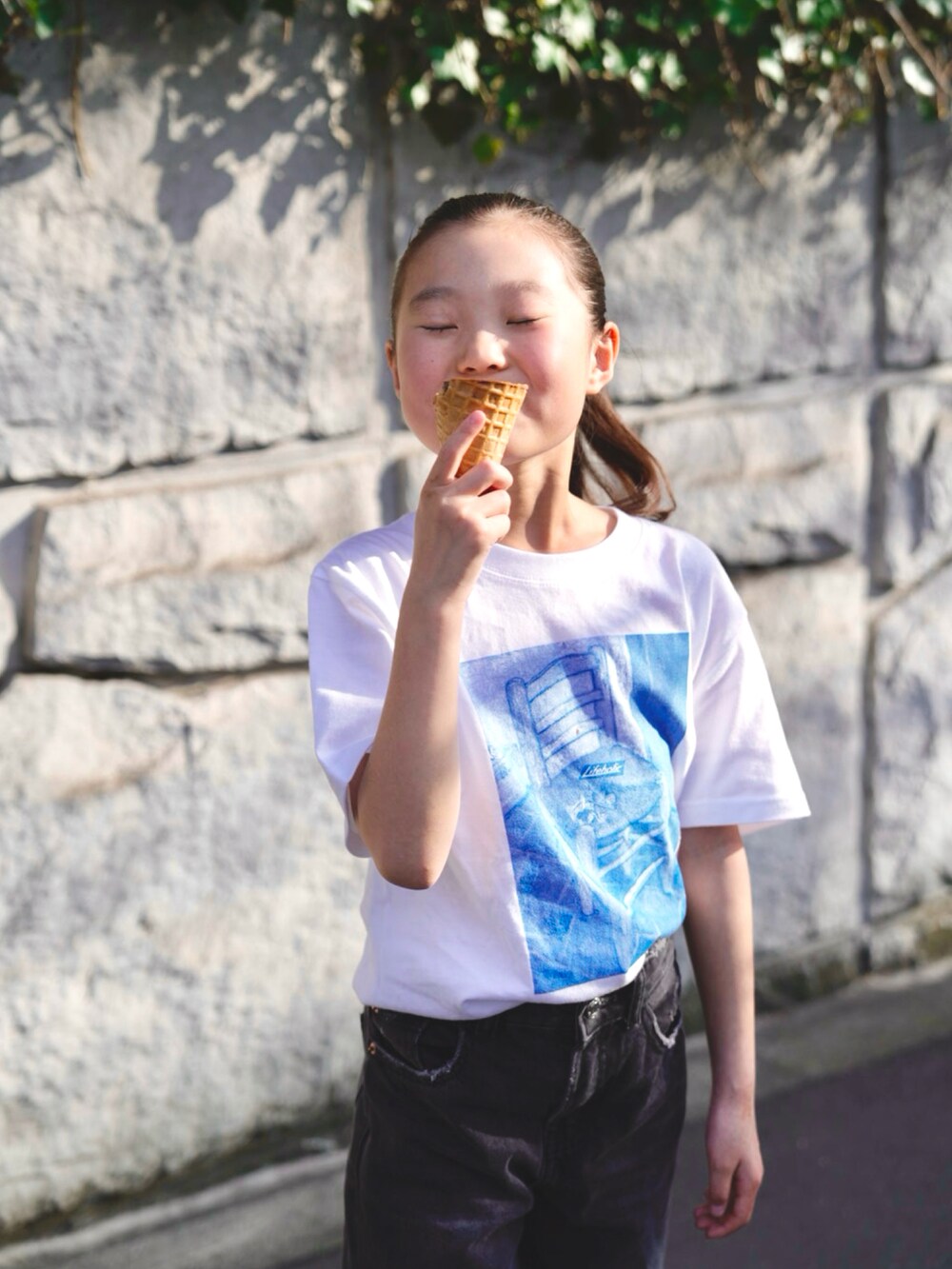 ブラック系のデニムパンツ、ブラック系のスニーカー、ホワイト系のTシャツ/カットソーを着用したキッズの春コーディネートの3枚目の写真