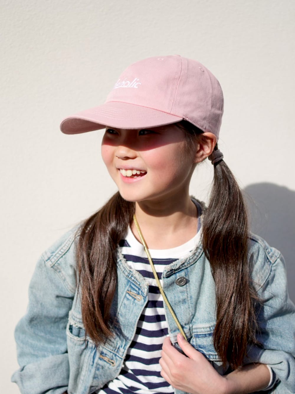 ブルー系のデニムパンツ、ブルー系のデニムジャケット、ゴールド系のショルダーバッグを着用したキッズの春コーディネートの3枚目の写真