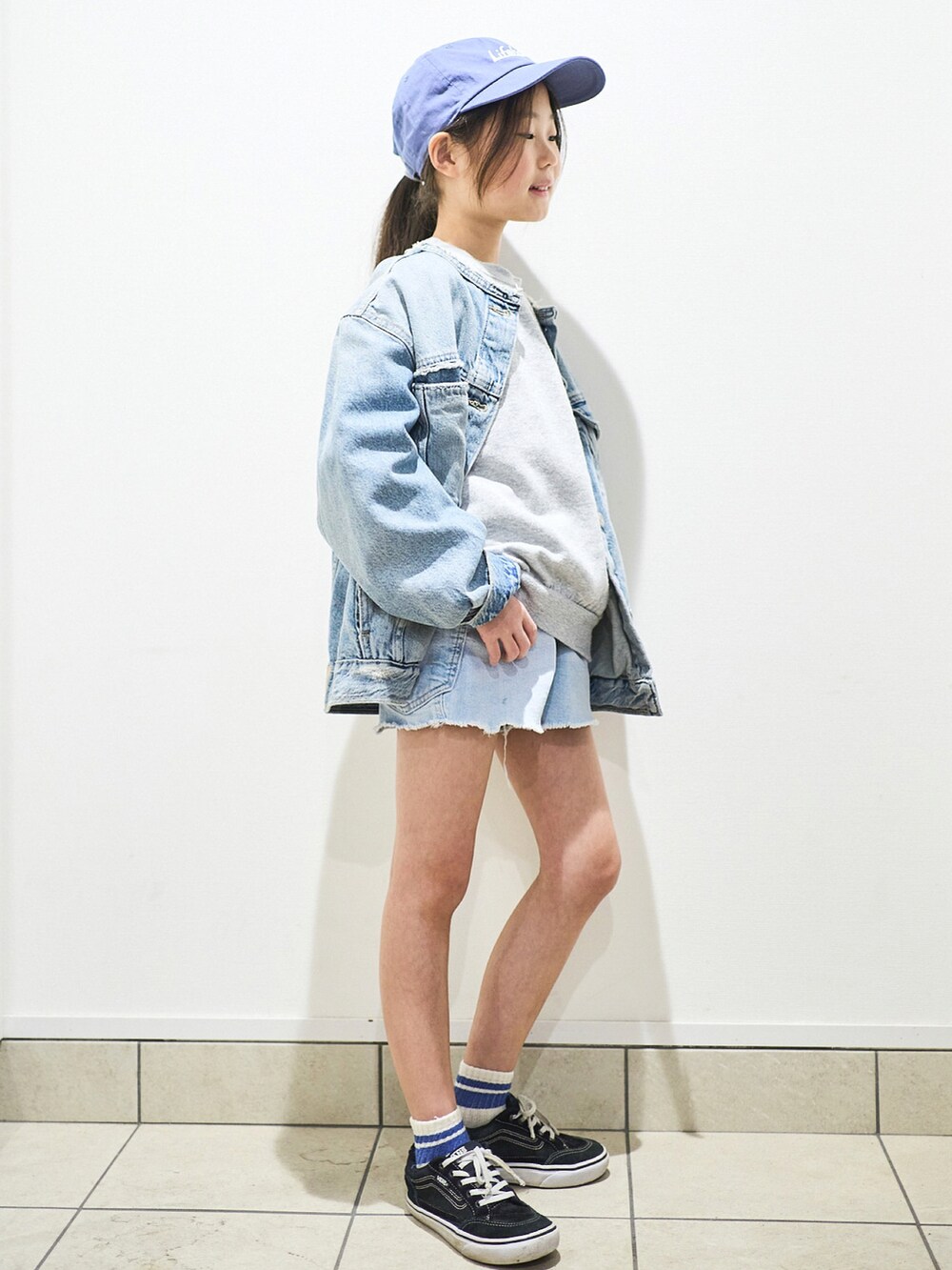 ブルー系のデニムジャケット、ブラック系のスニーカー、ブルー系のパンツを着用したキッズの春コーディネートの3枚目の写真