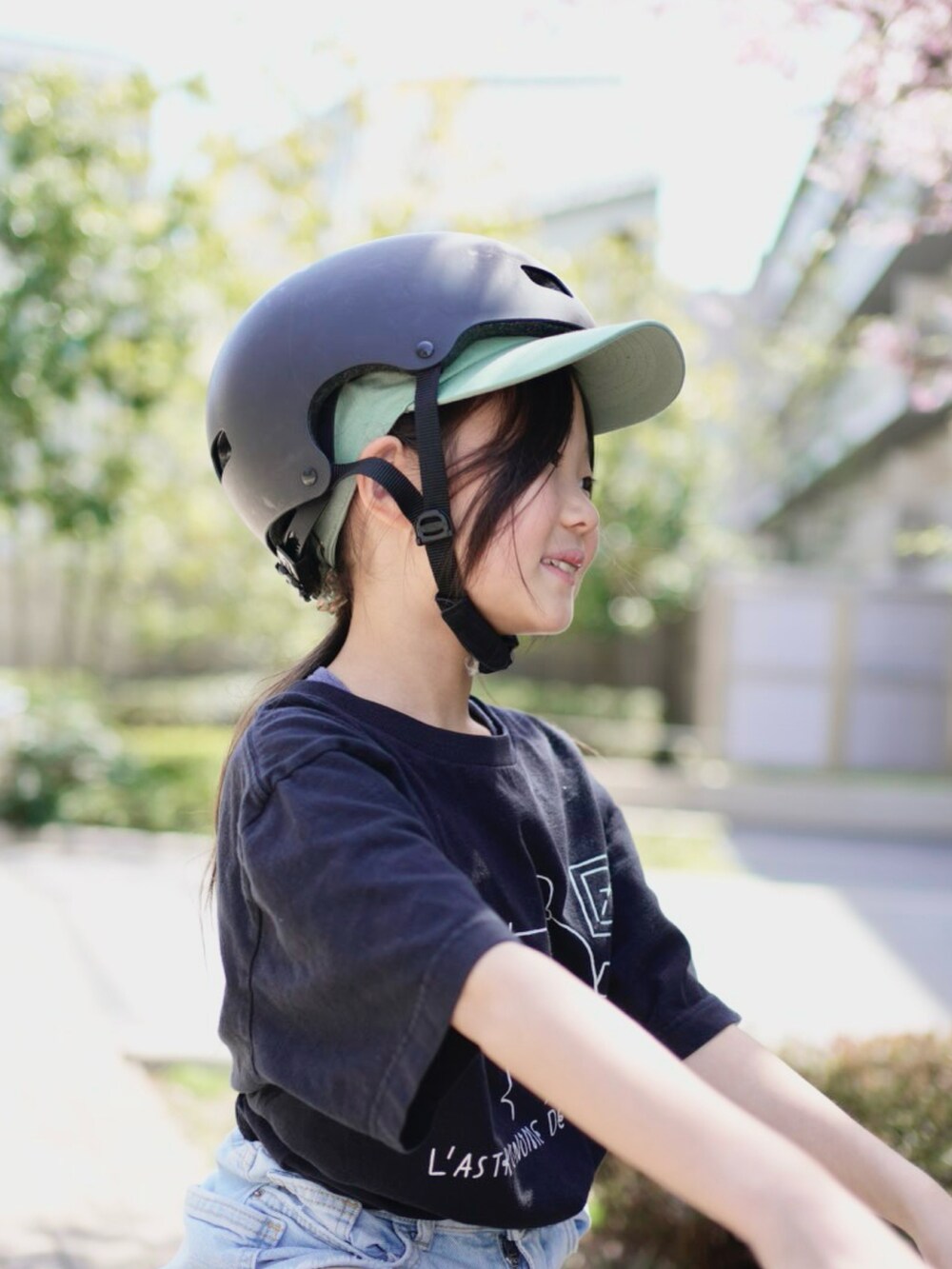ブラック系のTシャツ/カットソー、ブルー系のパンツ、ブラック系のスニーカーを着用したキッズの春コーディネートの2枚目の写真