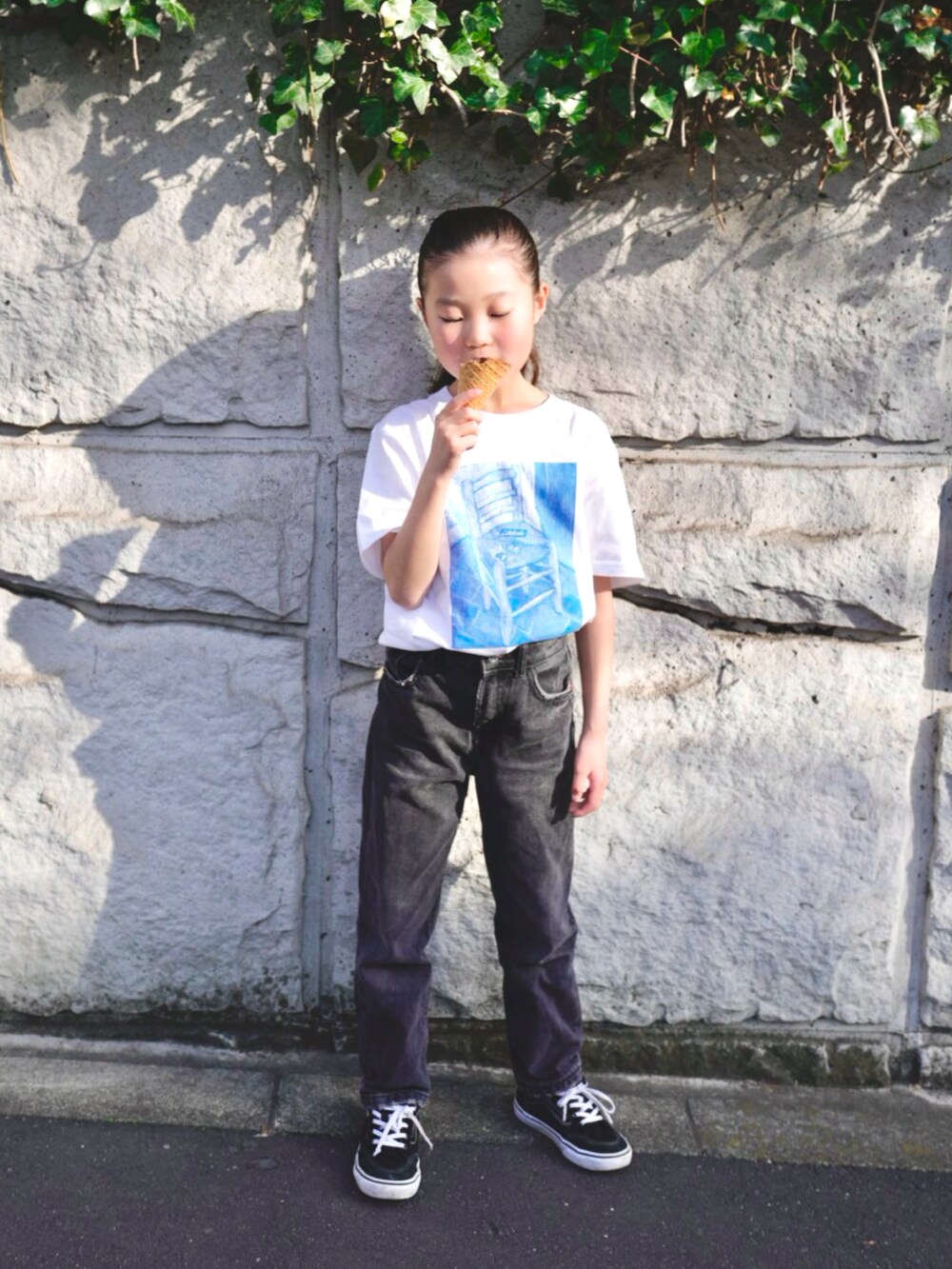 ブラック系のデニムパンツ、ブラック系のスニーカー、ホワイト系のTシャツ/カットソーを着用したキッズの春コーディネートの4枚目の写真