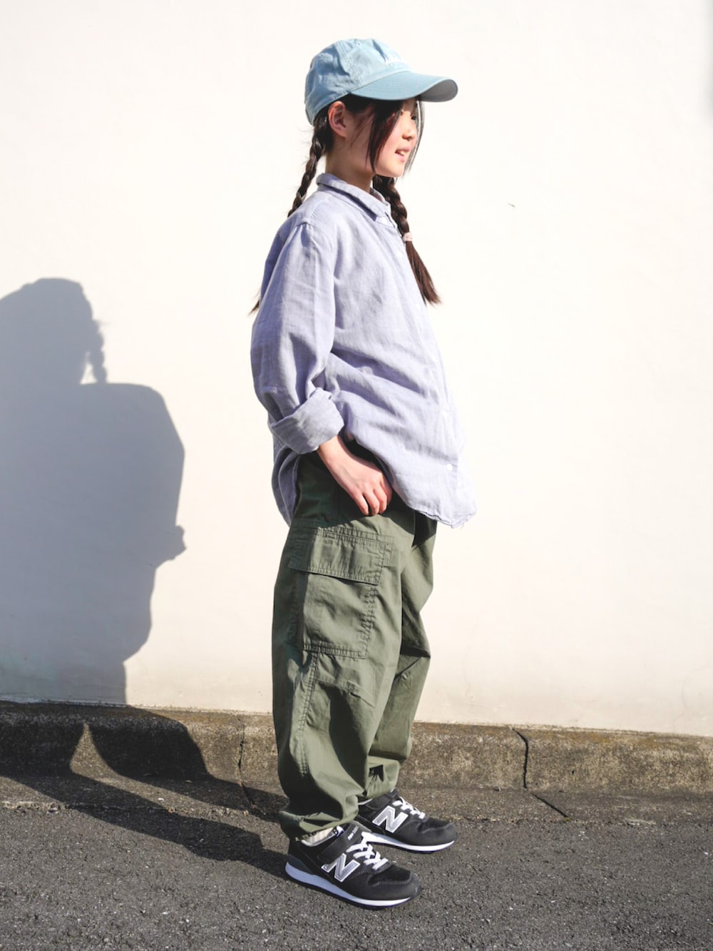 グリーン系のパンツ、ブラック系のスニーカー、ブルー系のシャツ/ブラウスを着用したキッズの春コーディネートの2枚目の写真