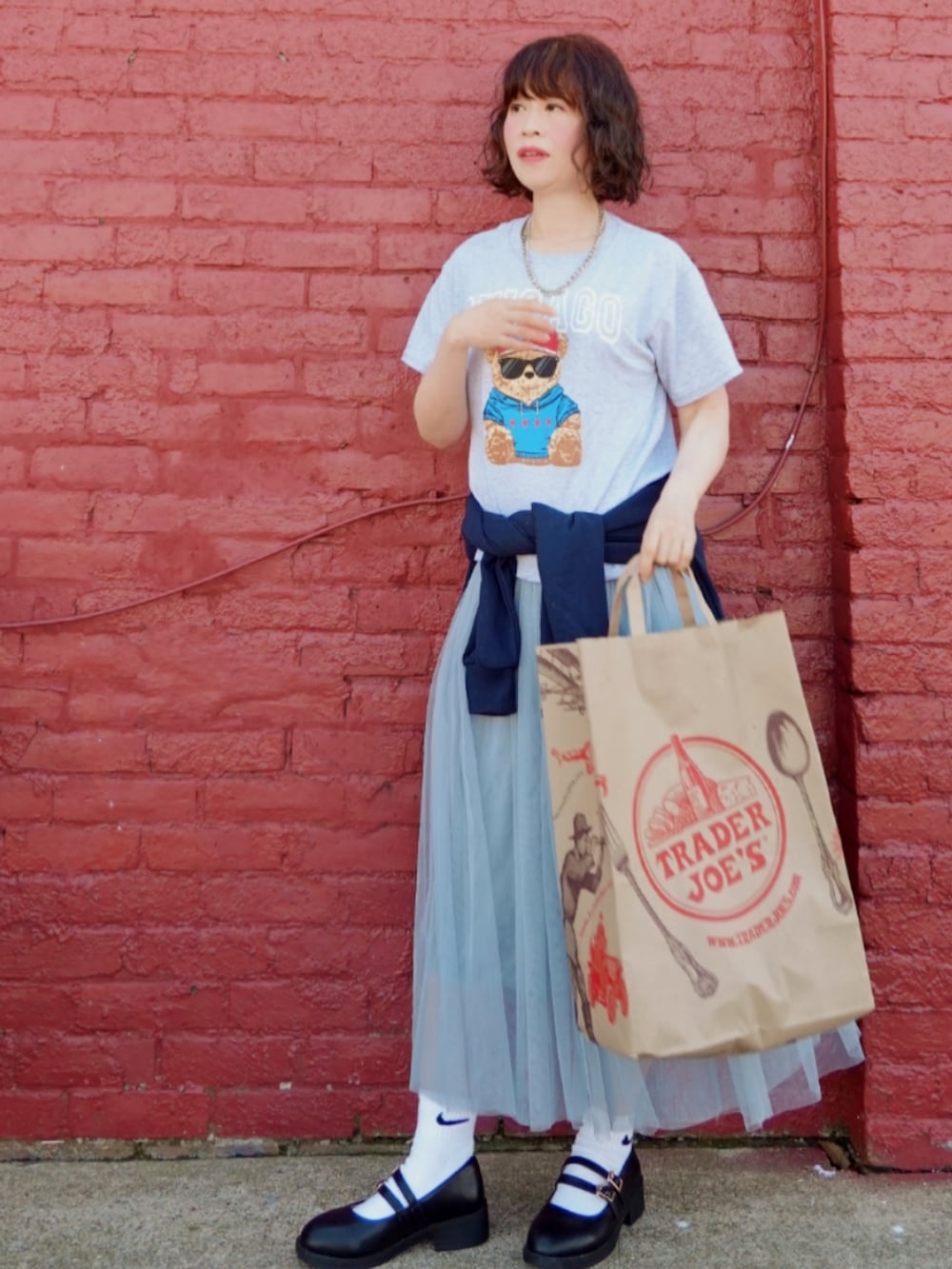 グレー系のスカート、ブラック系のドレスシューズ、グレー系のTシャツ/カットソーを着用したレディースの夏コーディネートの2枚目の写真