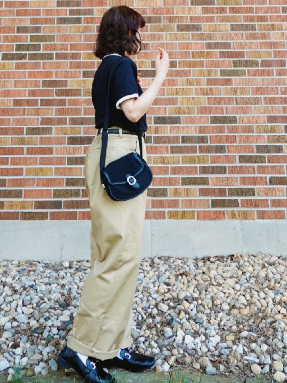 ベージュ系のチノパンツ、ブラック系のローファー、ブラック系のTシャツ/カットソーを着用したレディースの夏コーディネートの2枚目の写真