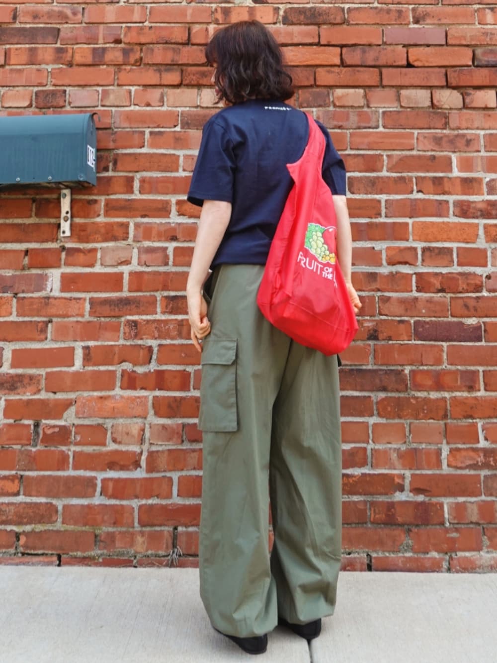 グリーン系のカーゴパンツ、ブルー系のTシャツ/カットソー、レッド系のトートバッグを着用したレディースの夏コーディネートの4枚目の写真