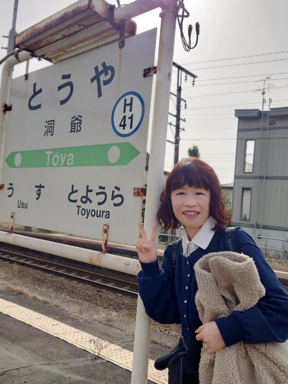 ブラック系のスニーカー、イエロー系のスカート、ブラック系のショルダーバッグを着用したレディースの秋コーディネートの3枚目の写真