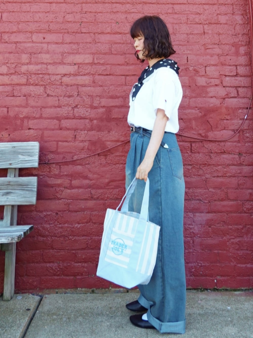 ブルー系のトートバッグ、ブルー系のデニムパンツ、ホワイト系のTシャツ/カットソーを着用したレディースの夏コーディネートの2枚目の写真