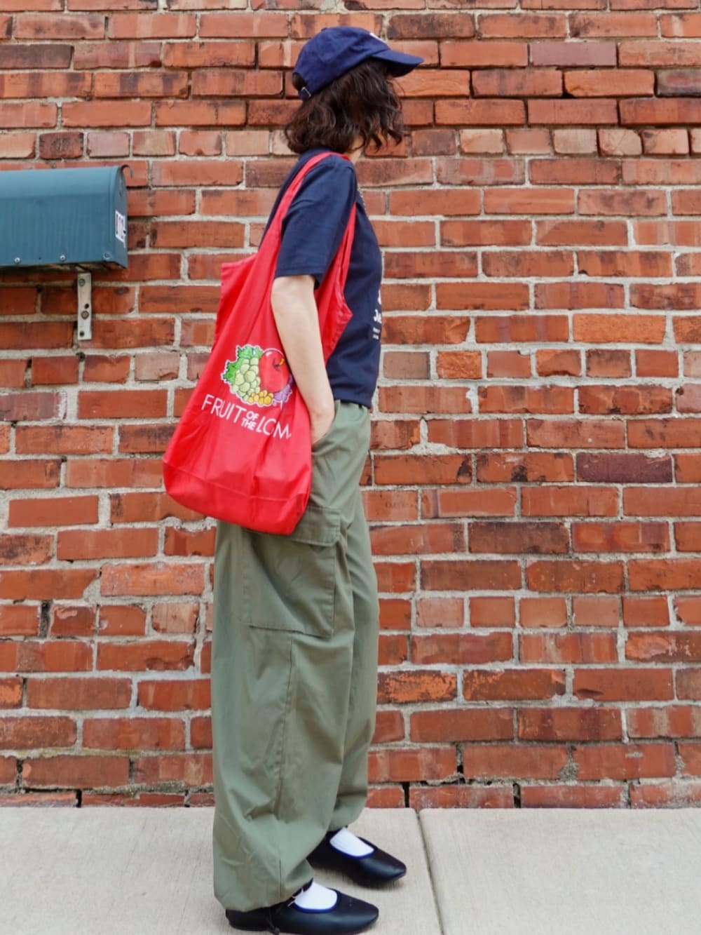 グリーン系のカーゴパンツ、ブルー系のTシャツ/カットソー、レッド系のトートバッグを着用したレディースの夏コーディネートの2枚目の写真