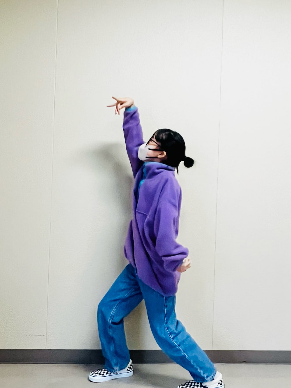 パープル系のスウェット、ブルー系のデニムパンツ、ブラック系のスリッポンを着用したキッズの冬コーディネートの2枚目の写真