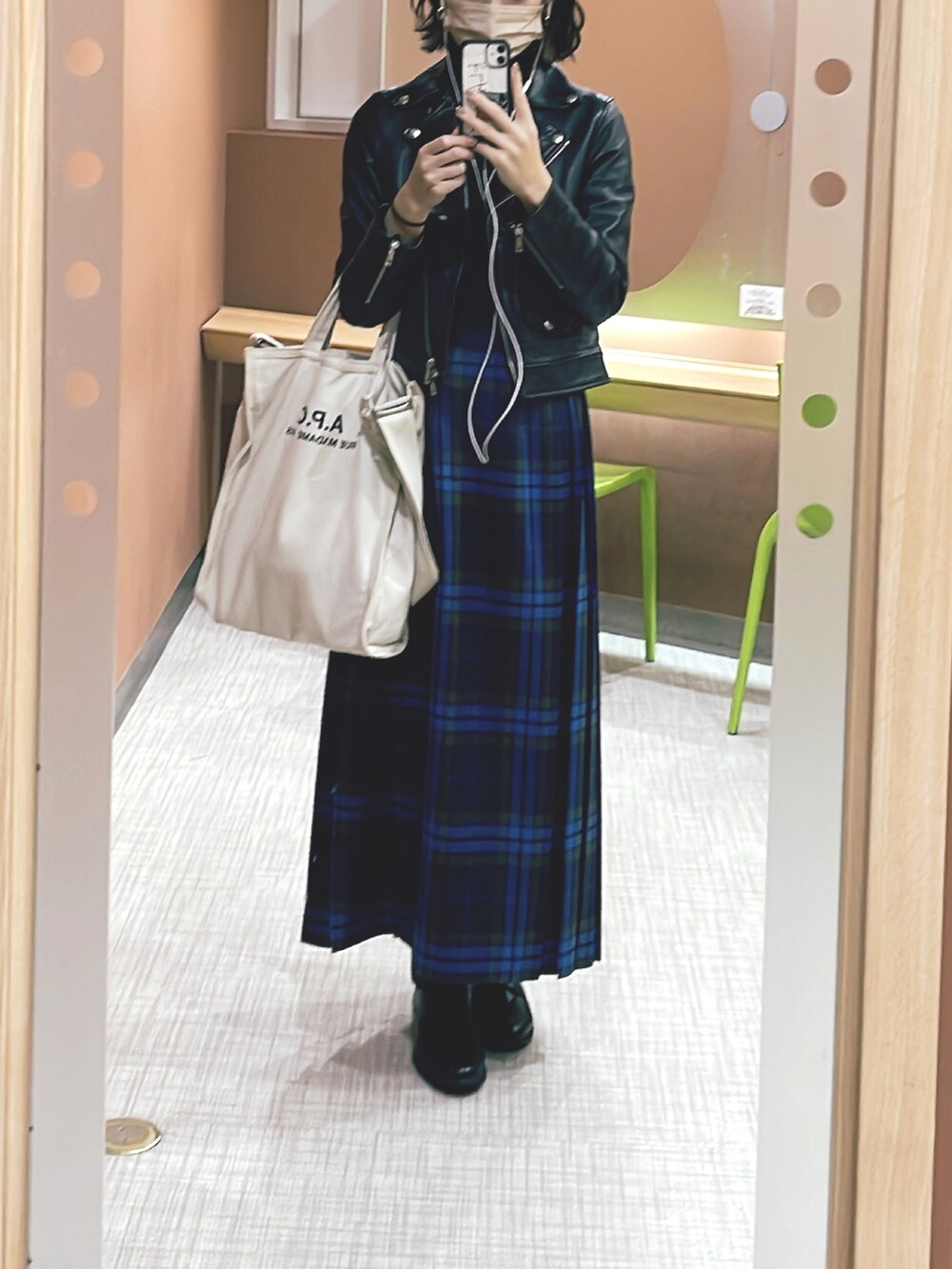 ベージュ系のトートバッグ、ブラック系のライダースジャケット、ブルー系のスカートを着用したレディースの春コーディネートの2枚目の写真