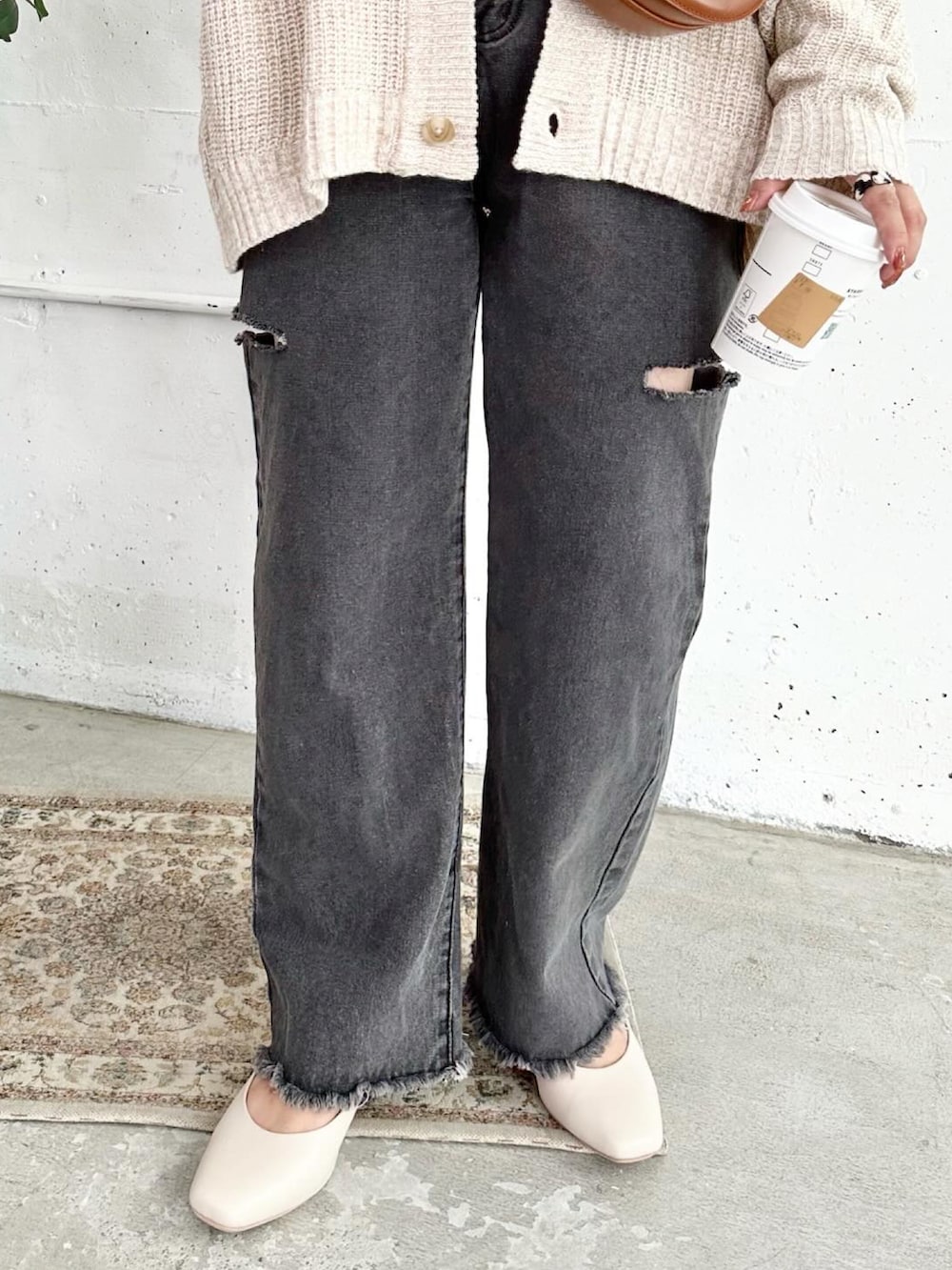 ベージュ系のパンプス、ブラック系のデニムパンツ、ブラウン系のショルダーバッグを着用したレディースの秋コーディネートの4枚目の写真