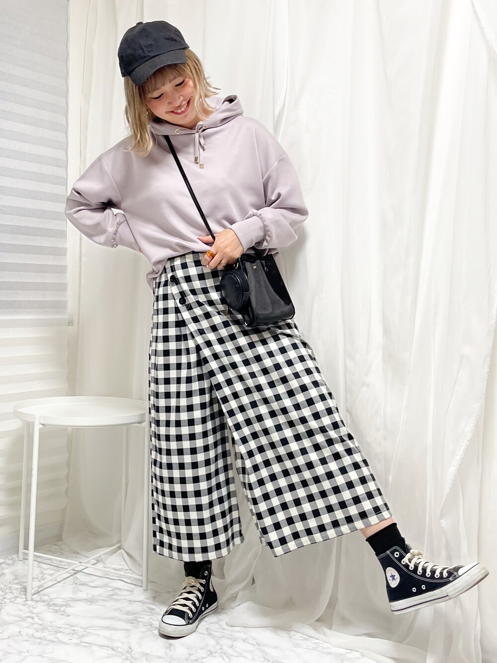 ブラック系のスニーカー、ブラック系のパンツ、ブラック系のショルダーバッグを着用したレディースの冬コーディネートの2枚目の写真