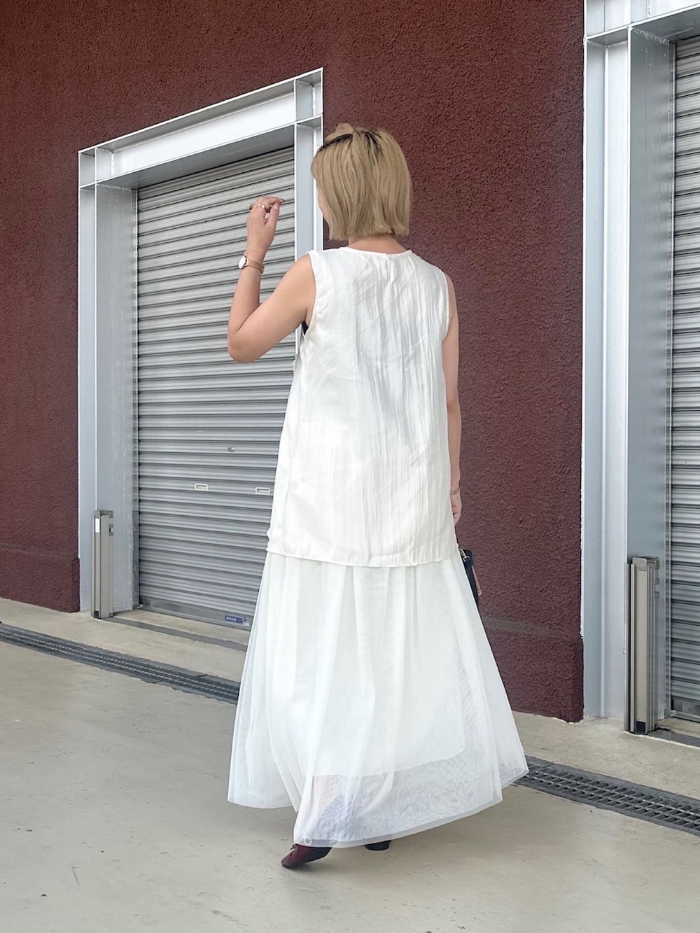 ホワイト系のトップスを着用したレディースの夏コーディネートの4枚目の写真