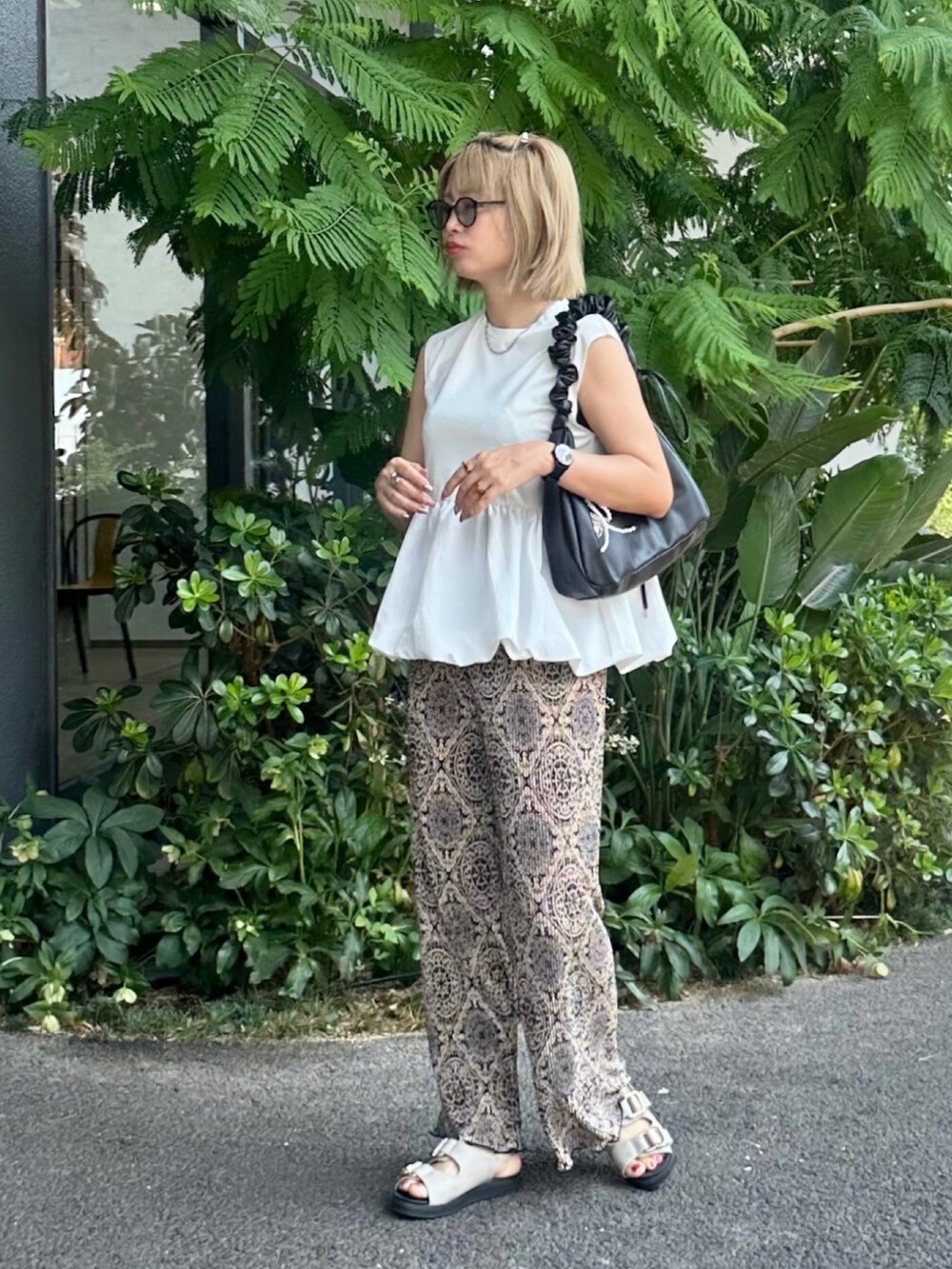 グレー系のサンダル、ホワイト系のタンクトップ、ブラック系のその他パンツを着用したレディースの夏コーディネートの3枚目の写真