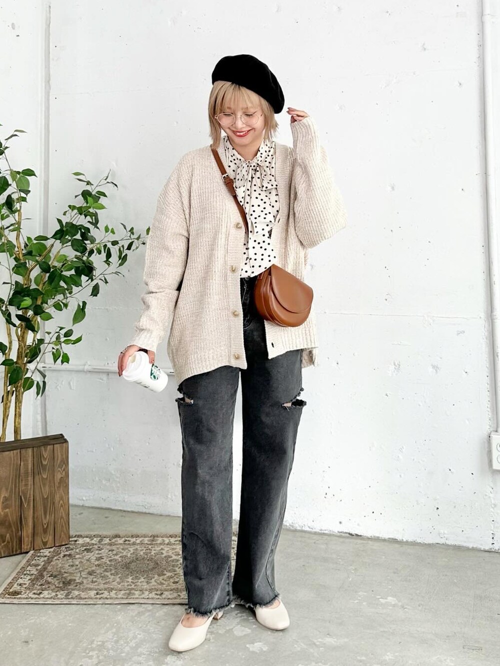 ベージュ系のパンプス、ブラック系のデニムパンツ、ブラウン系のショルダーバッグを着用したレディースの秋コーディネートの3枚目の写真