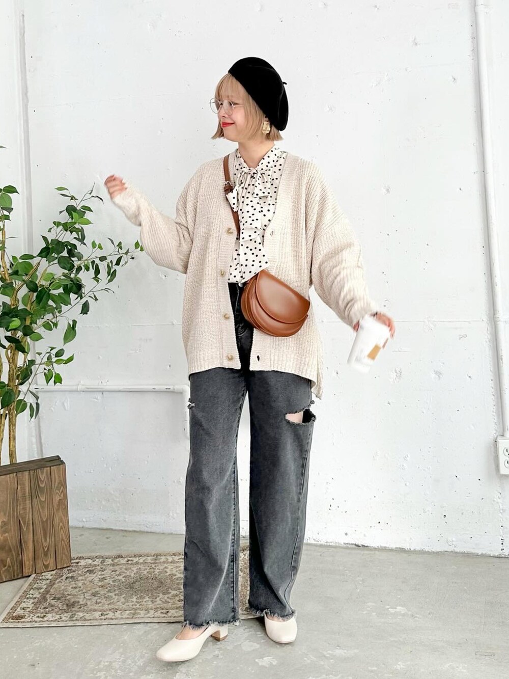 ベージュ系のパンプス、ブラック系のデニムパンツ、ブラウン系のショルダーバッグを着用したレディースの秋コーディネートの2枚目の写真