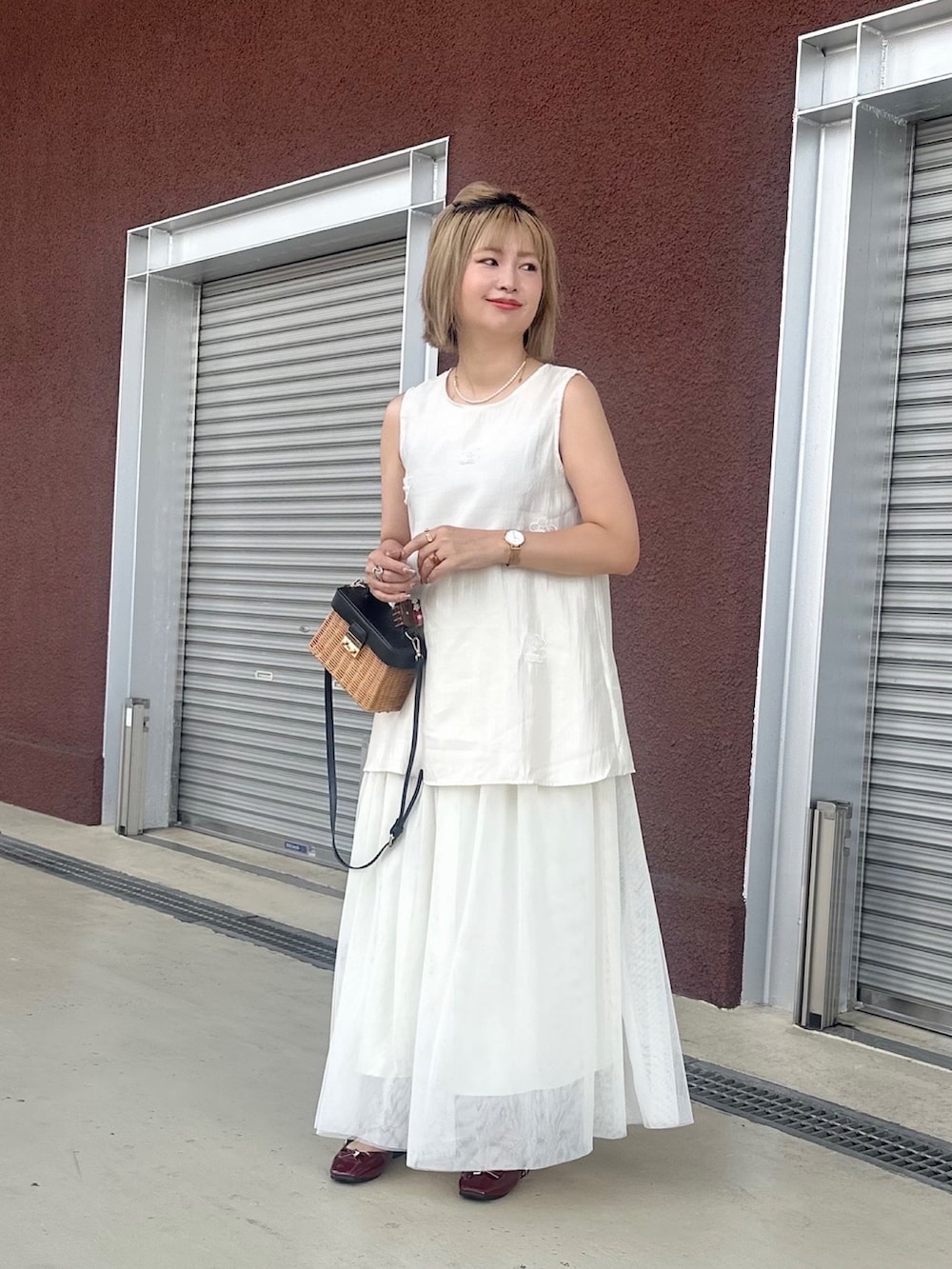 ホワイト系のトップスを着用したレディースの夏コーディネートの2枚目の写真