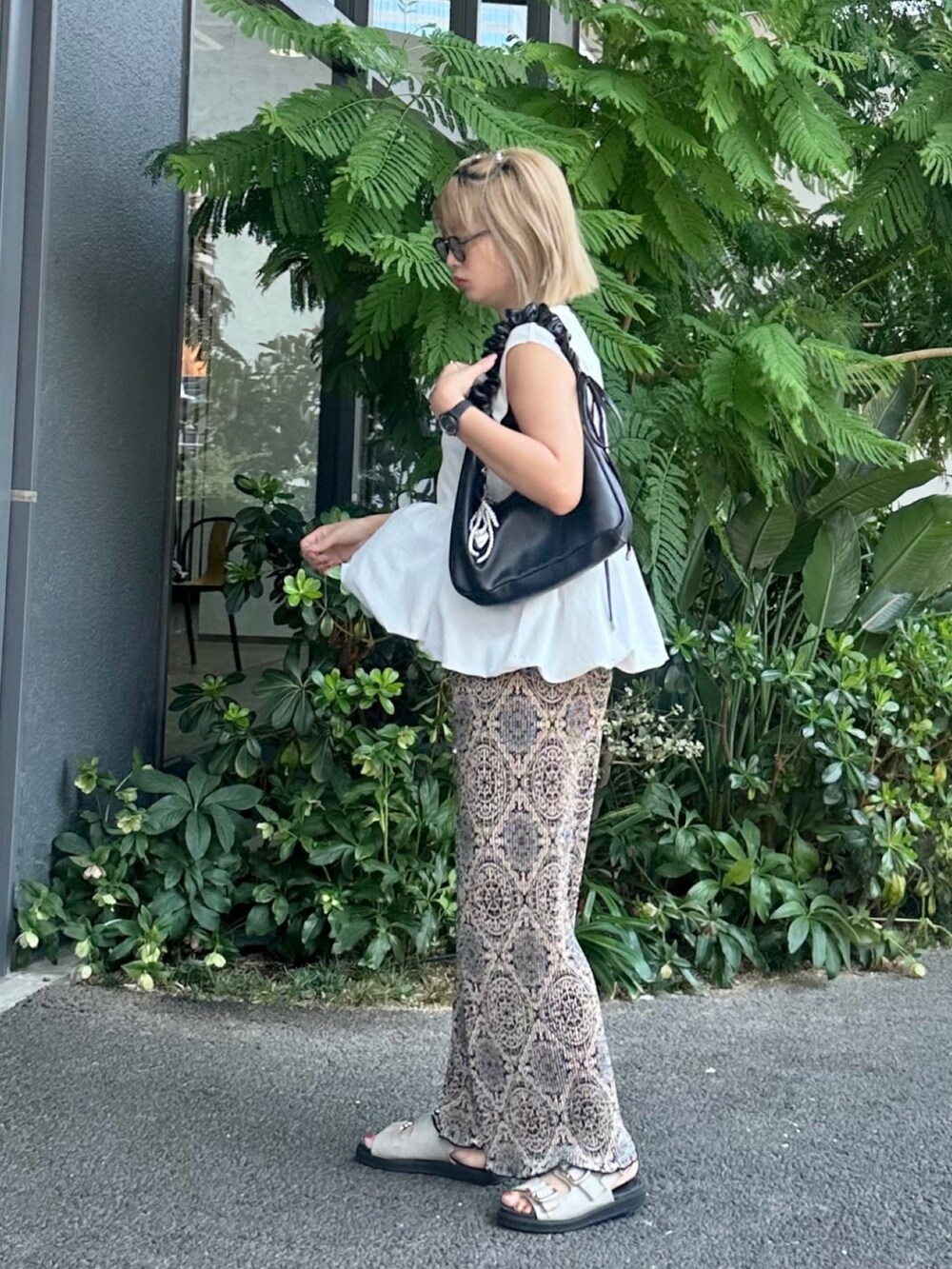 グレー系のサンダル、ホワイト系のタンクトップ、ブラック系のその他パンツを着用したレディースの夏コーディネートの2枚目の写真