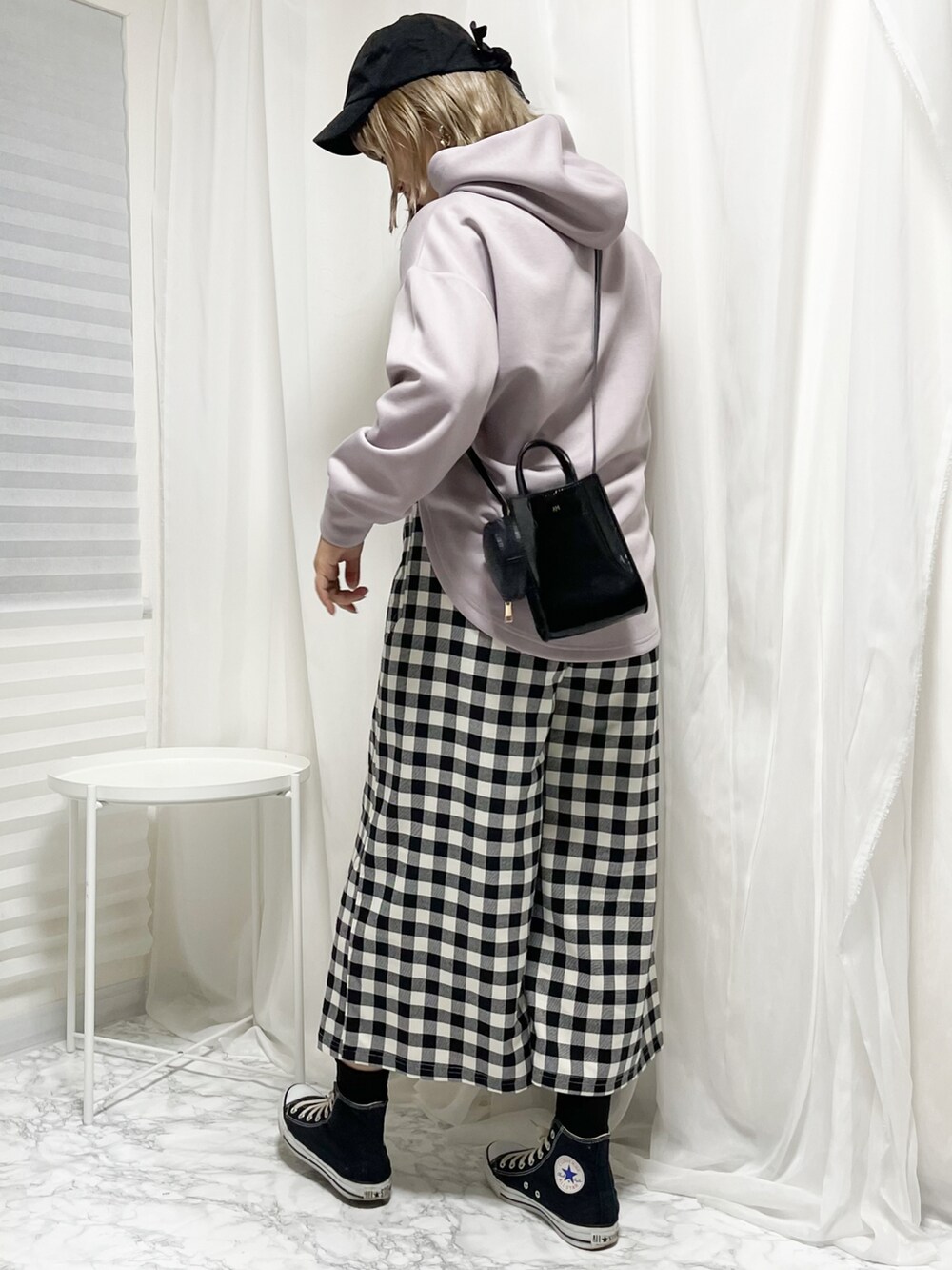 ブラック系のスニーカー、ブラック系のパンツ、ブラック系のショルダーバッグを着用したレディースの冬コーディネートの3枚目の写真