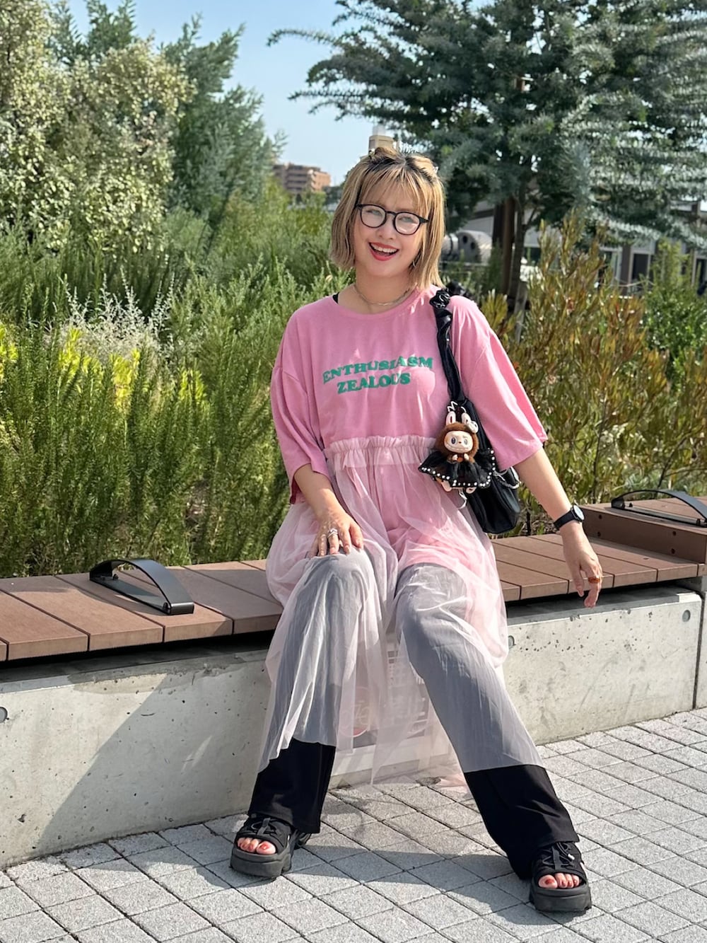 ブラック系のサンダル、ピンク系のワンピース、シルバー系のネックレスを着用したレディースの夏コーディネートの2枚目の写真