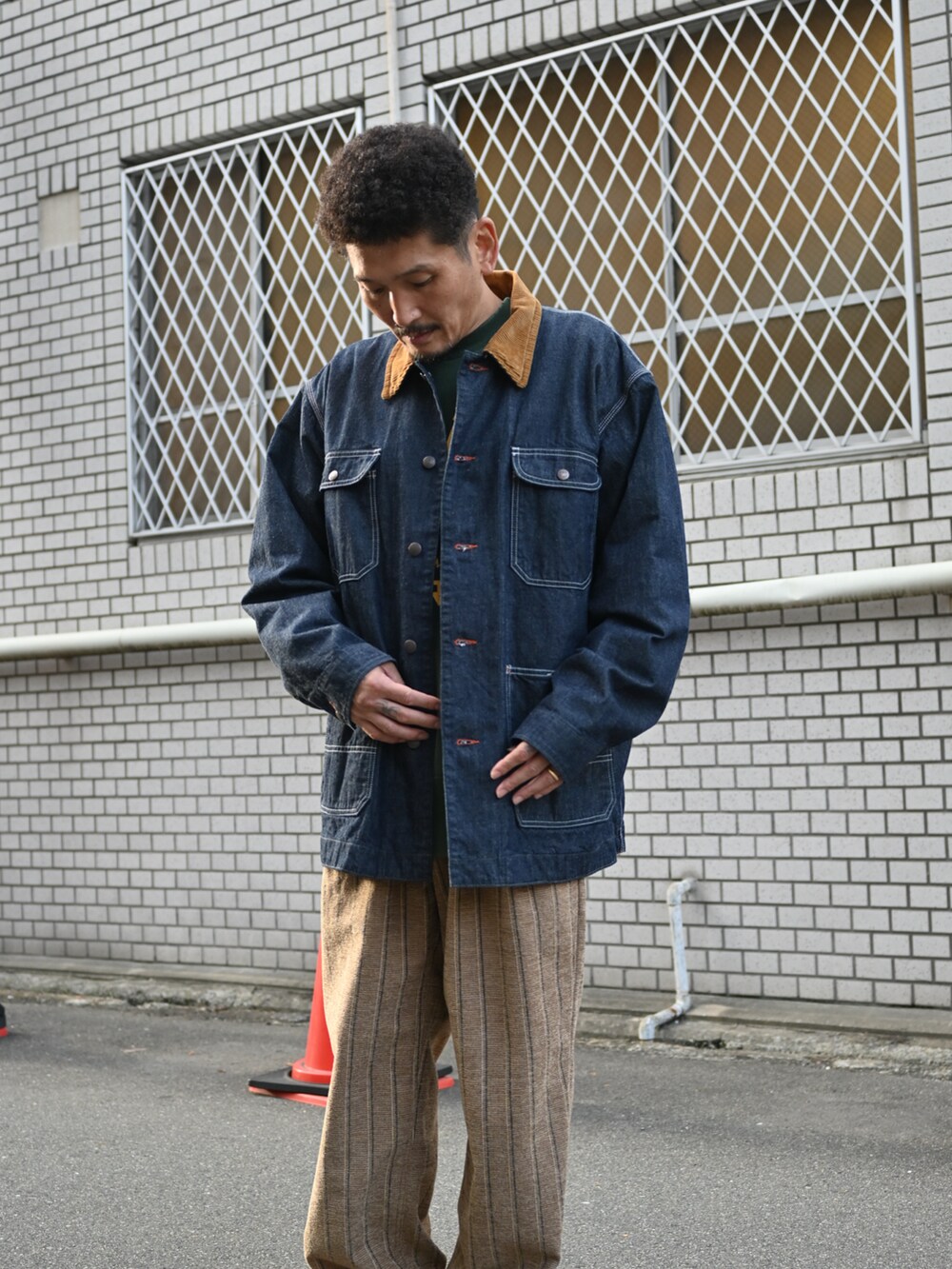 グリーン系のスウェット、ブルー系のデニムジャケット、ブラウン系のその他パンツを着用したメンズの秋コーディネートの3枚目の写真