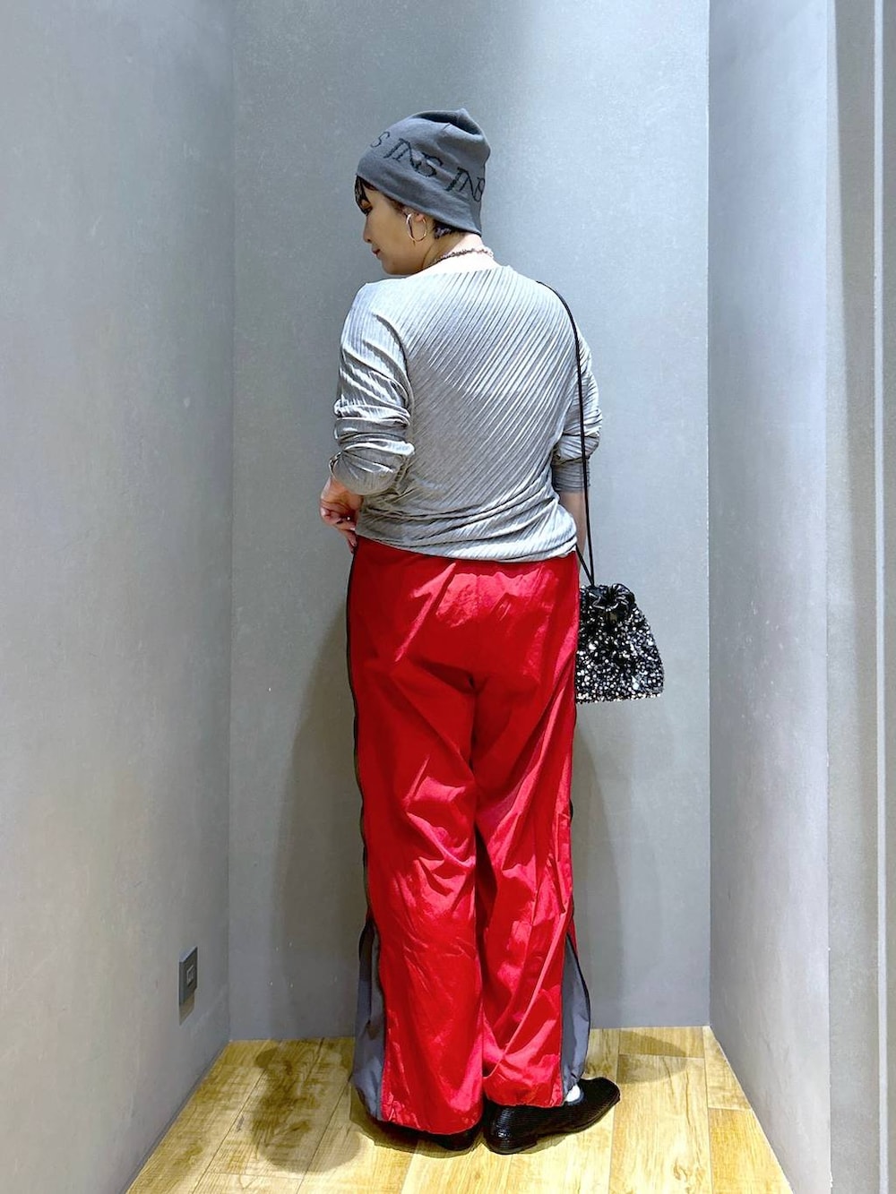 シルバー系のショルダーバッグ、ブラック系のパンプス、レッド系のその他パンツを着用したレディースの春コーディネートの4枚目の写真