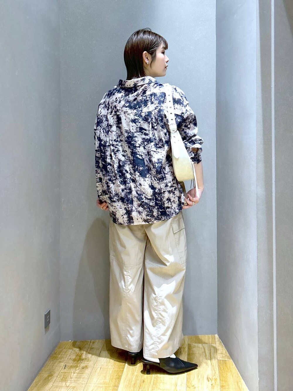 ホワイト系のショルダーバッグ、ブラック系のパンプス、ベージュ系のシャツ/ブラウスを着用したレディースの春コーディネートの4枚目の写真