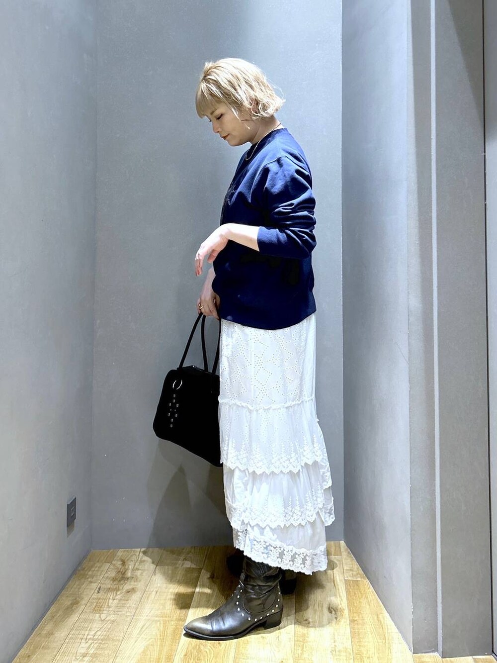 ブラック系のボストンバッグ、ブラック系のブーツ、ブルー系のスウェットを着用したレディースの冬コーディネートの4枚目の写真