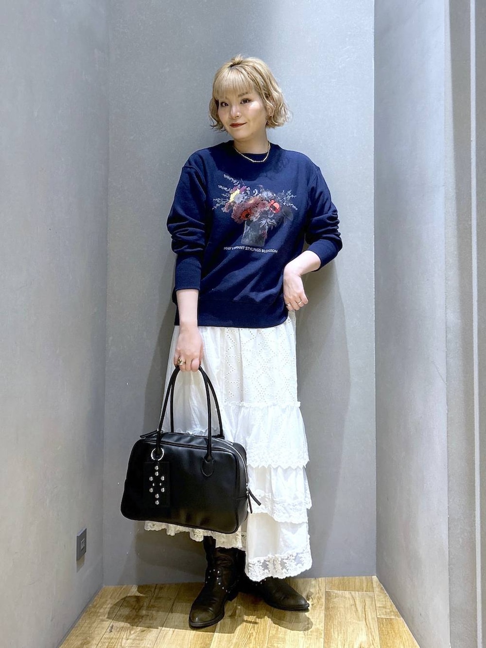 ブラック系のボストンバッグ、ブラック系のブーツ、ブルー系のスウェットを着用したレディースの冬コーディネートの3枚目の写真