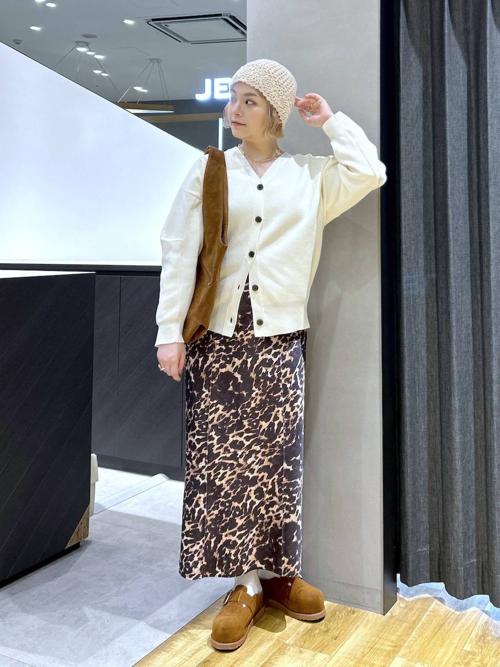 ブラウン系のその他シューズ、ブラウン系のトートバッグ、ホワイト系のカーディガン/ボレロを着用したレディースの秋コーディネートの3枚目の写真