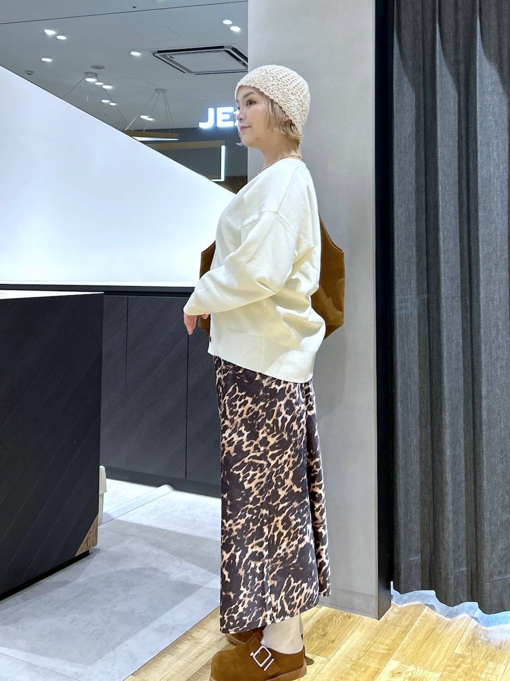 ブラウン系のその他シューズ、ブラウン系のトートバッグ、ホワイト系のカーディガン/ボレロを着用したレディースの秋コーディネートの4枚目の写真