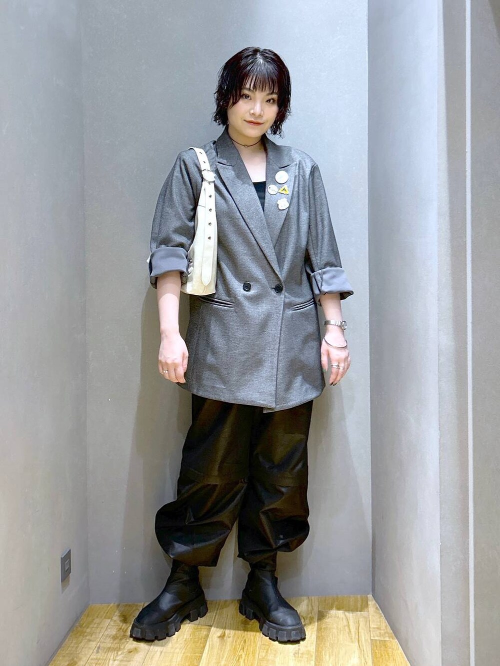 ホワイト系のショルダーバッグ、グレー系のテーラードジャケット、ブラック系のその他パンツを着用したレディースの秋コーディネートの2枚目の写真