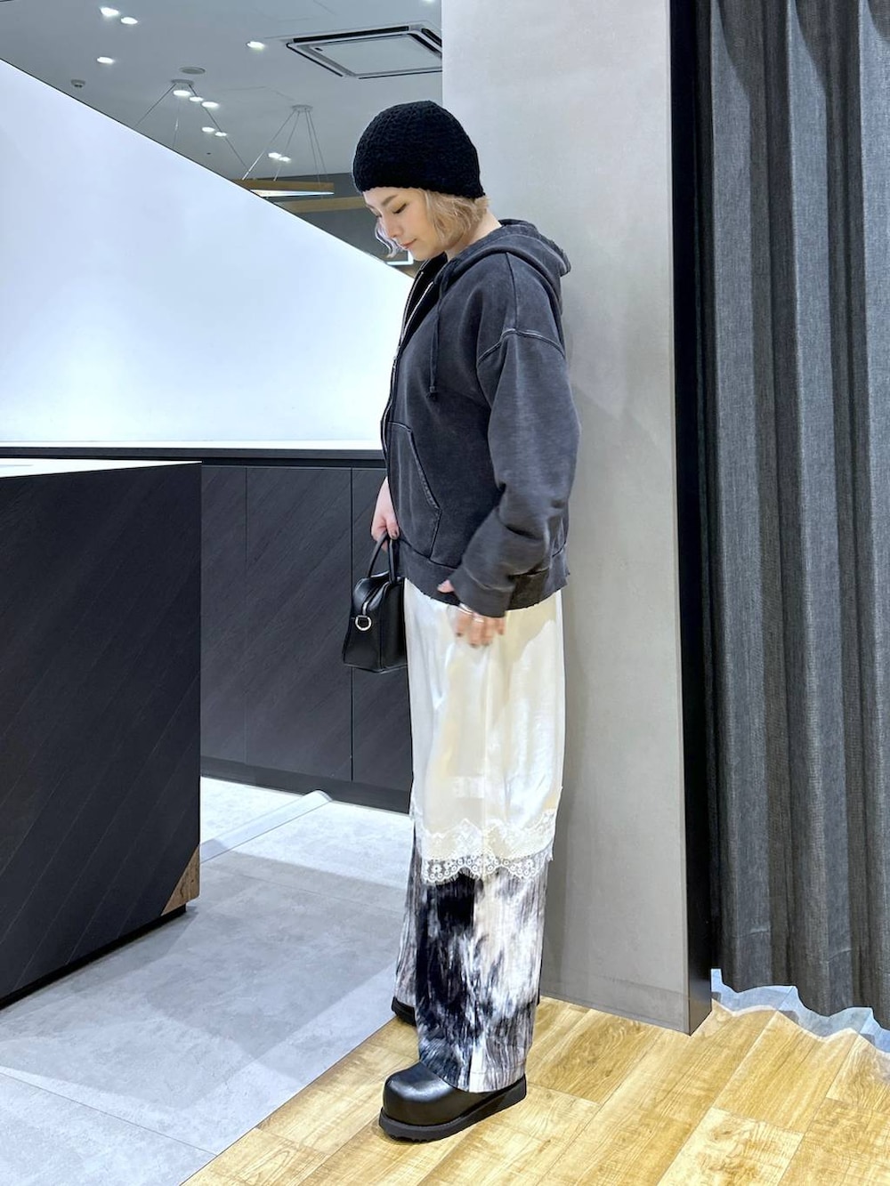 ブラック系のショルダーバッグ、ブラック系のパーカー、ブラック系のその他シューズを着用したレディースの秋コーディネートの3枚目の写真