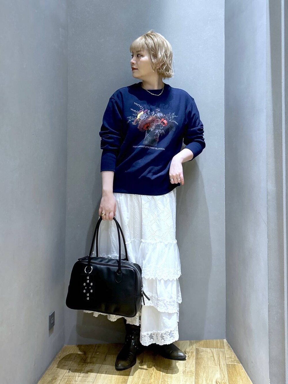 ブラック系のボストンバッグ、ブラック系のブーツ、ブルー系のスウェットを着用したレディースの冬コーディネートの2枚目の写真