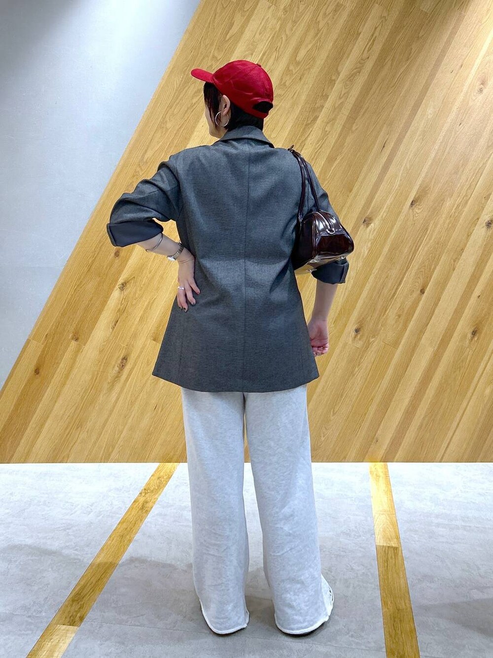 グレー系のテーラードジャケット、グレー系のスウェットパンツ、レッド系のボストンバッグを着用したレディースの冬コーディネートの3枚目の写真