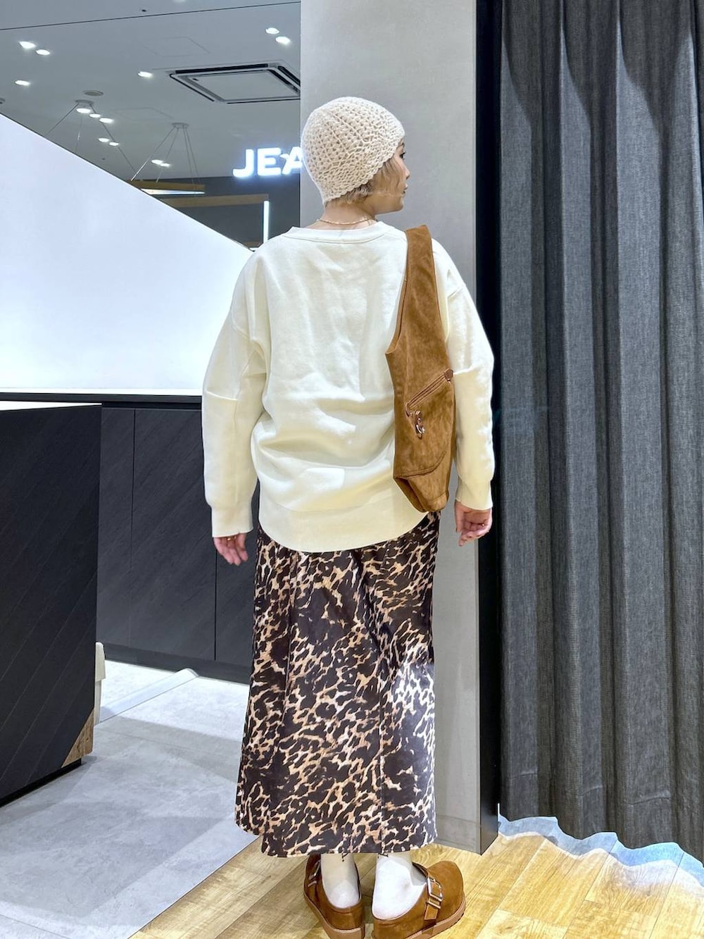 ブラウン系のその他シューズ、ブラウン系のトートバッグ、ホワイト系のカーディガン/ボレロを着用したレディースの秋コーディネートの5枚目の写真