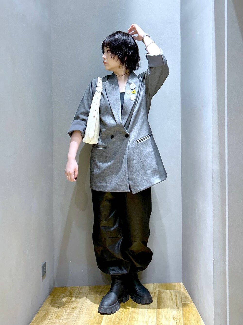 ホワイト系のショルダーバッグ、グレー系のテーラードジャケット、ブラック系のその他パンツを着用したレディースの秋コーディネートの3枚目の写真