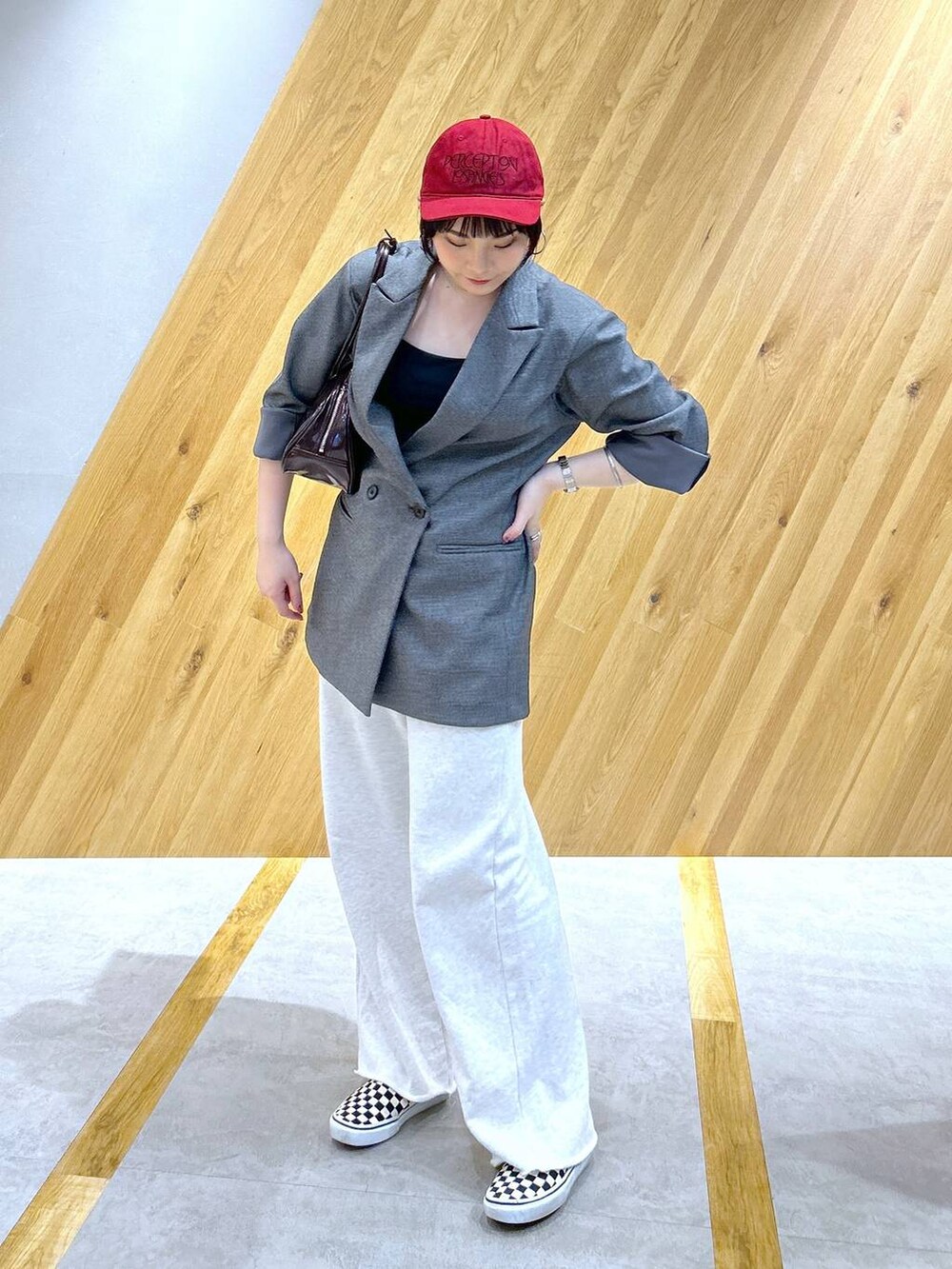 グレー系のテーラードジャケット、グレー系のスウェットパンツ、レッド系のボストンバッグを着用したレディースの冬コーディネートの2枚目の写真