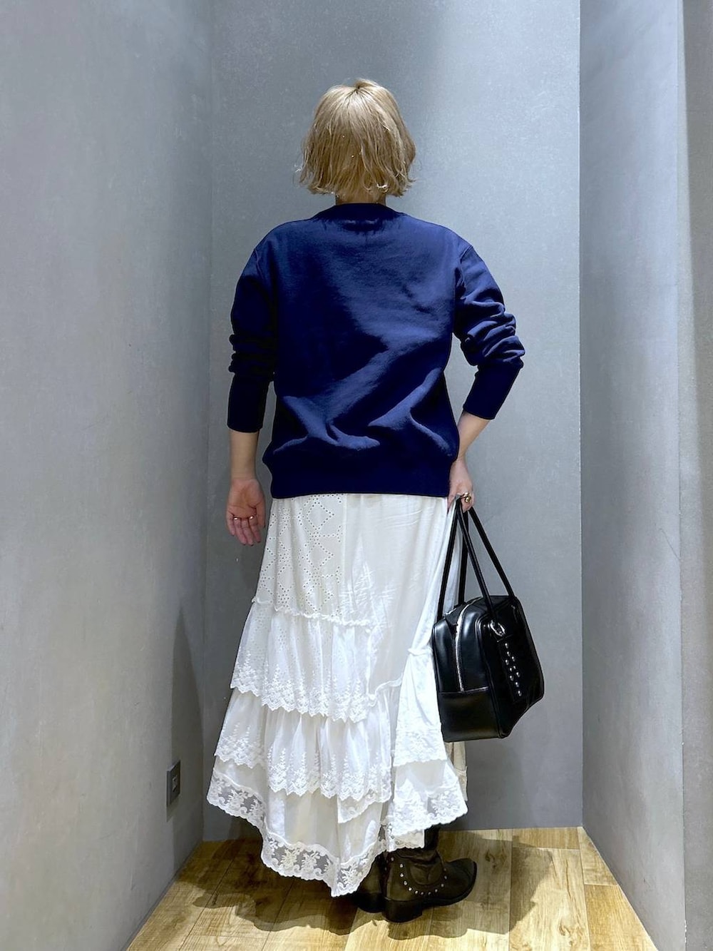 ブラック系のボストンバッグ、ブラック系のブーツ、ブルー系のスウェットを着用したレディースの冬コーディネートの5枚目の写真