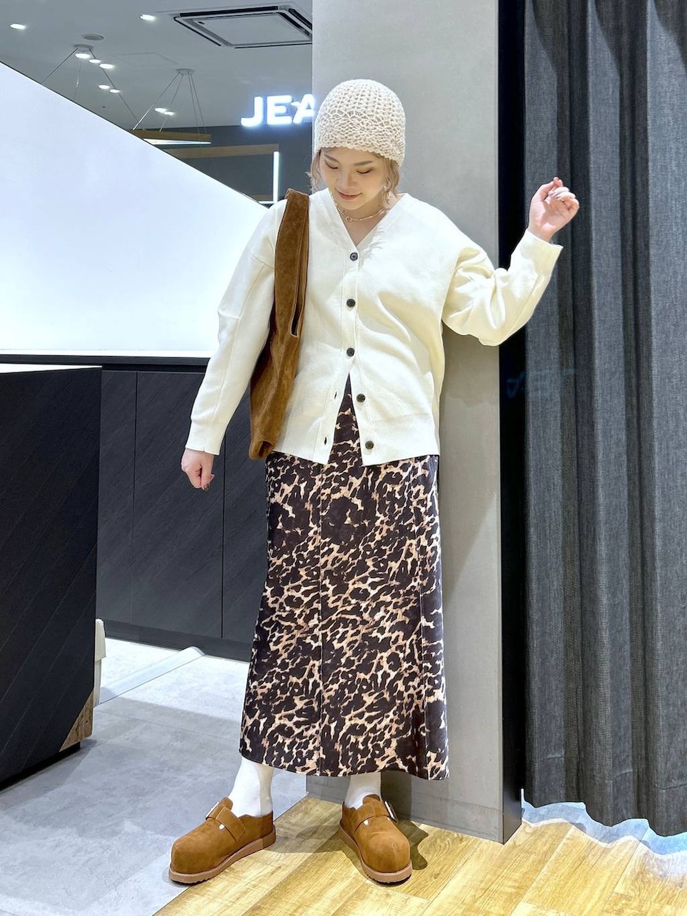 ブラウン系のその他シューズ、ブラウン系のトートバッグ、ホワイト系のカーディガン/ボレロを着用したレディースの秋コーディネートの2枚目の写真