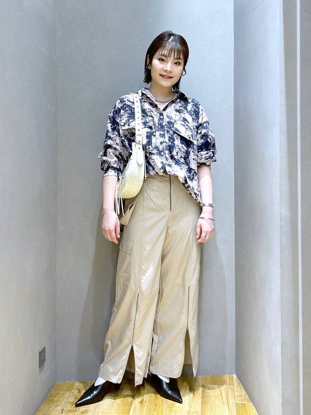 ホワイト系のショルダーバッグ、ブラック系のパンプス、ベージュ系のシャツ/ブラウスを着用したレディースの春コーディネートの3枚目の写真