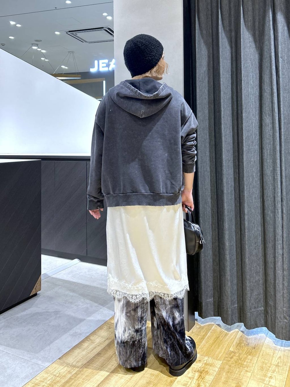 ブラック系のショルダーバッグ、ブラック系のパーカー、ブラック系のその他シューズを着用したレディースの秋コーディネートの5枚目の写真