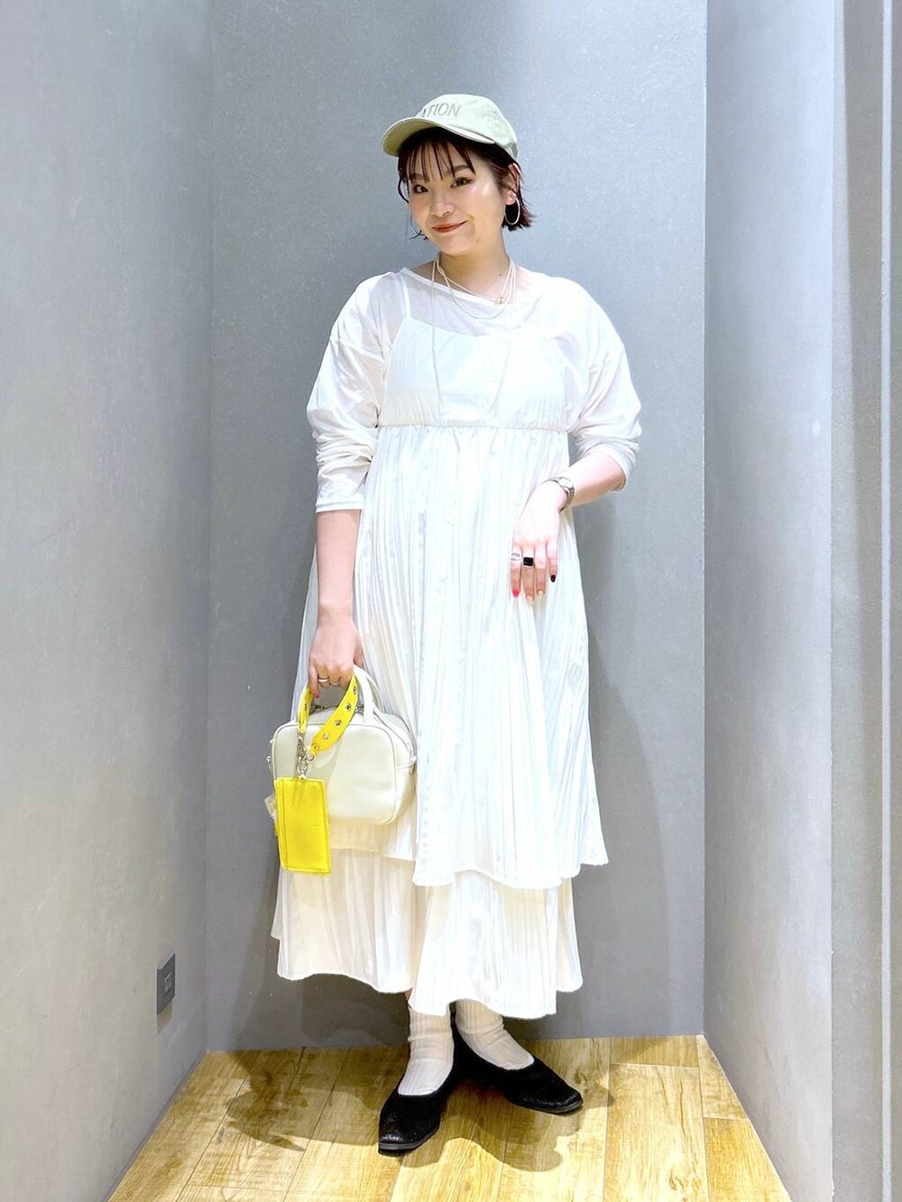 ホワイト系のショルダーバッグ、ホワイト系のワンピース、ブラック系のパンプスを着用したレディースの春コーディネートの4枚目の写真