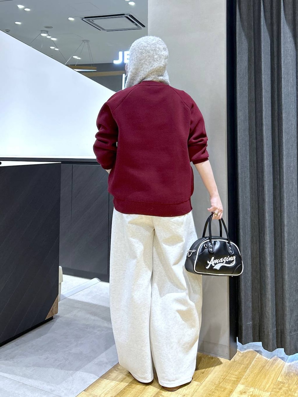 ブラック系のショルダーバッグ、ブラウン系のその他シューズ、レッド系のニット/セーターを着用したレディースの秋コーディネートの4枚目の写真