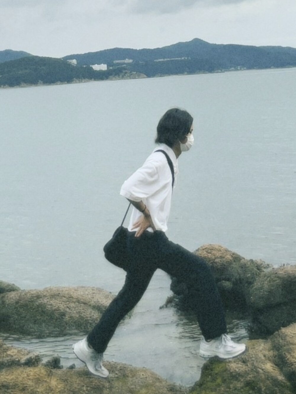 グレー系のスニーカー、ブラック系のキャップを着用したメンズの冬コーディネートの2枚目の写真