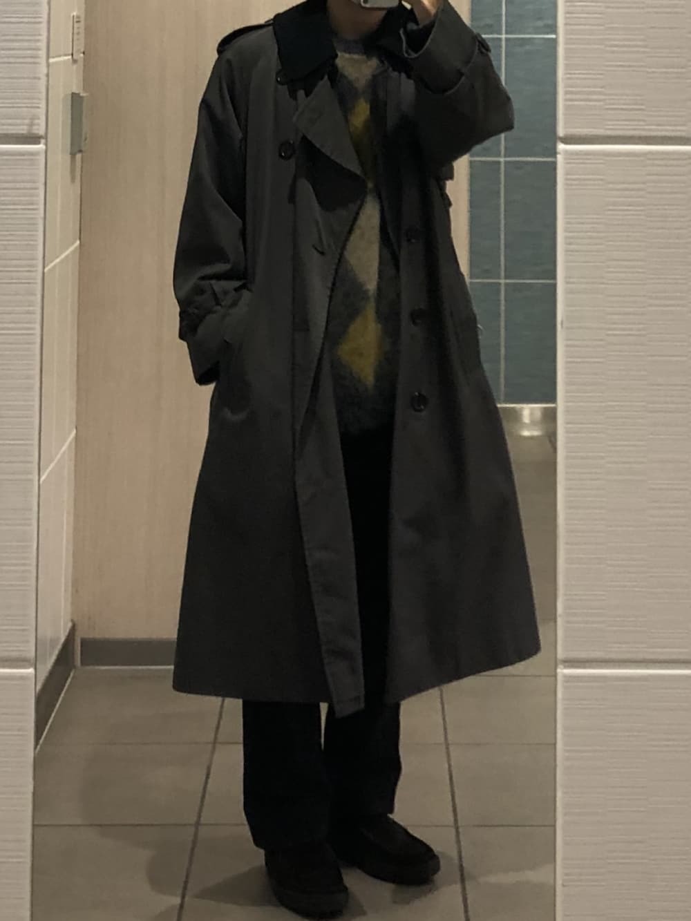 グリーン系のニット/セーター、グレー系のトレンチコート、ブラック系のデニムパンツを着用したメンズの冬コーディネートの2枚目の写真