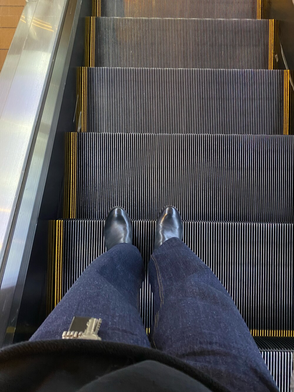 グレー系のダウンジャケット/コート、ブラック系のキーケース/キーアクセサリーを着用したメンズの冬コーディネートの2枚目の写真