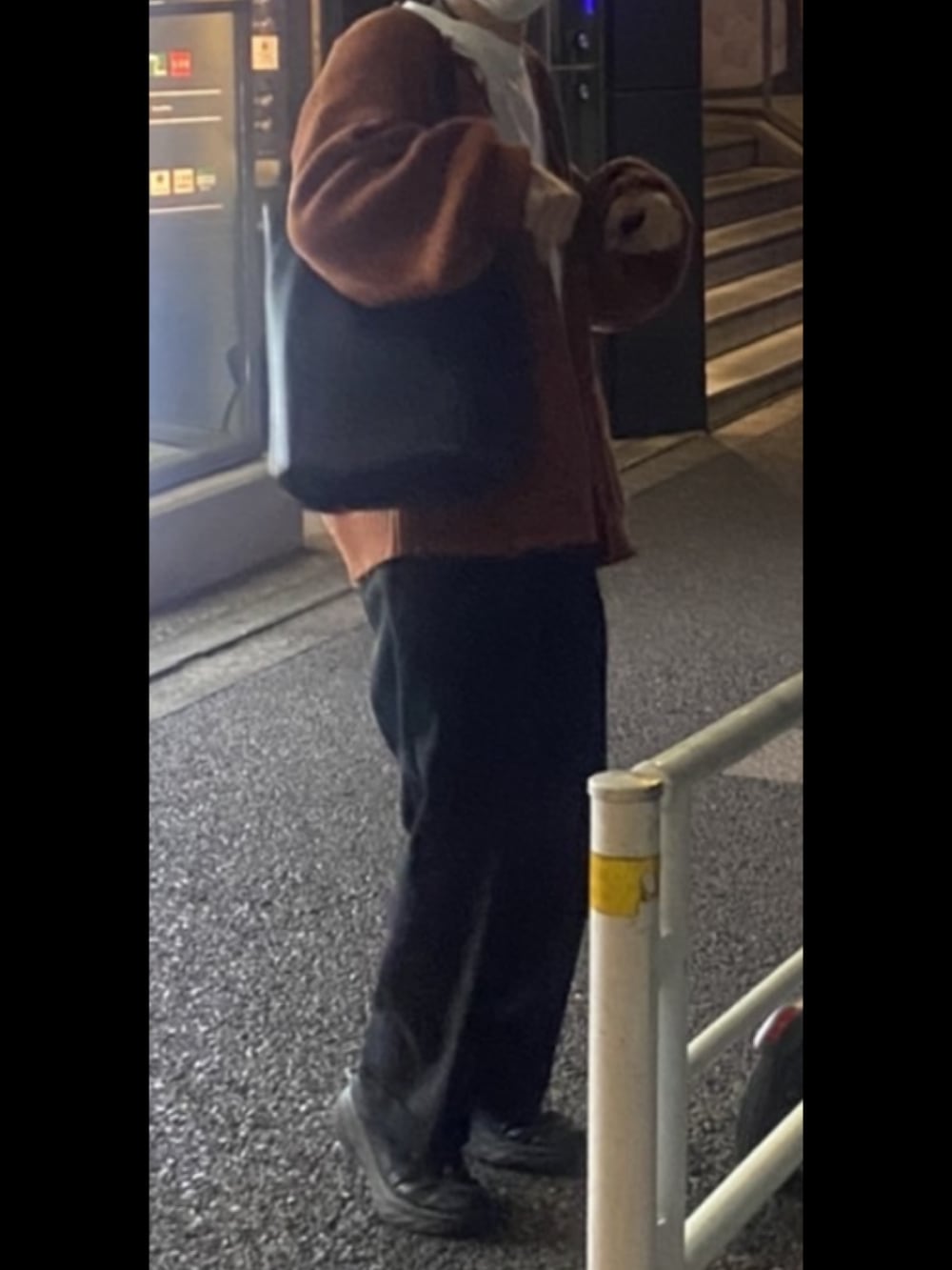 ブラック系のデニムパンツ、オレンジ系のカーディガン/ボレロ、ブラック系のローファーを着用したメンズの冬コーディネートの3枚目の写真