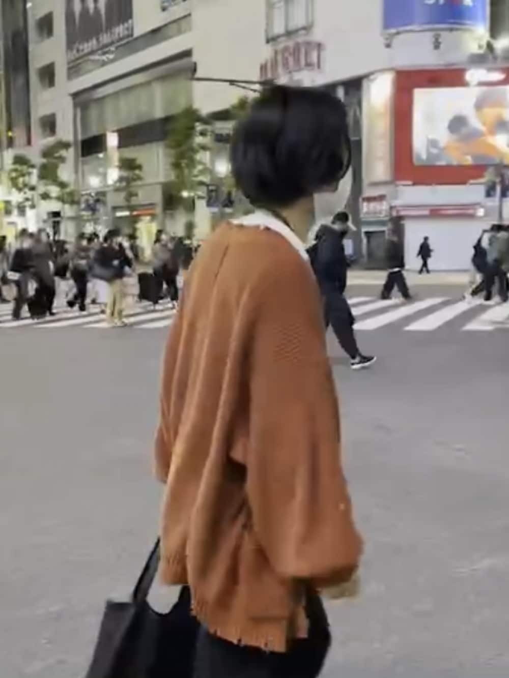 ブラック系のデニムパンツ、オレンジ系のカーディガン/ボレロ、ブラック系のローファーを着用したメンズの冬コーディネートの2枚目の写真