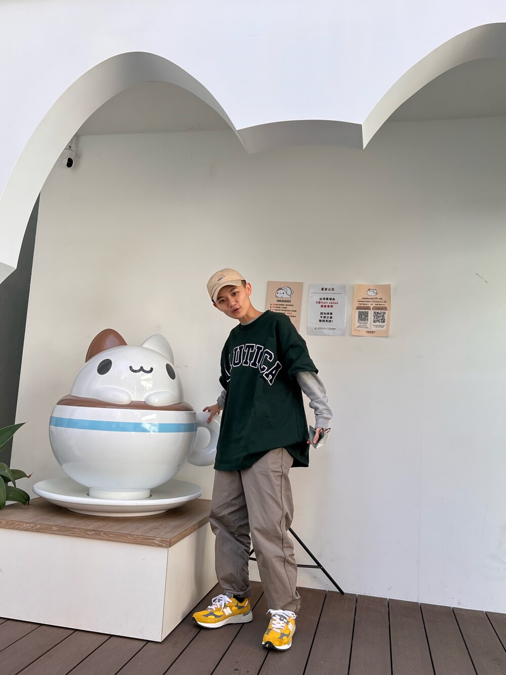 グリーン系のTシャツ/カットソー、ブラウン系のチノパンツ、イエロー系のスニーカーを着用したメンズの冬コーディネートの2枚目の写真